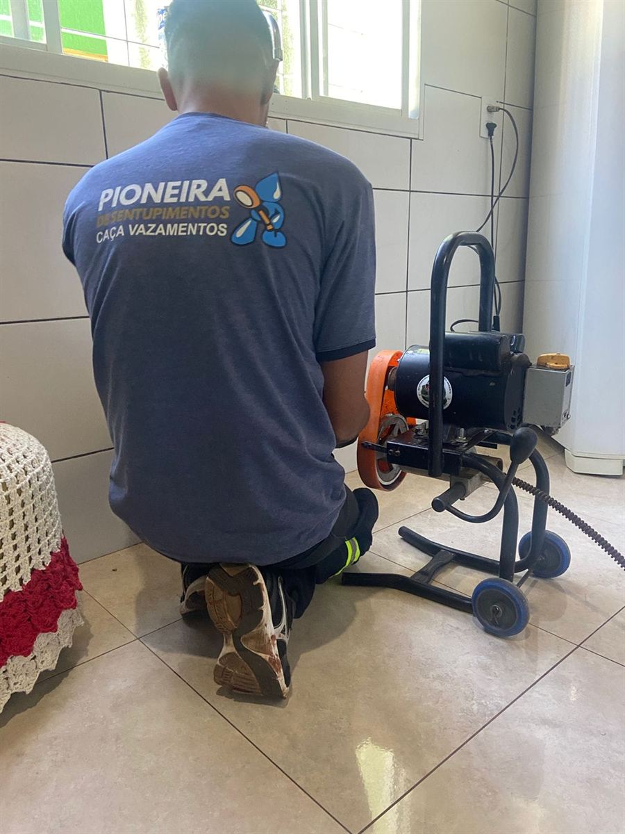 Máquina de desentupimento em uso em uma cozinha residencial